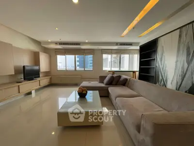 Spacious modern living room with large sofa and city view, perfect for relaxation and entertainment.