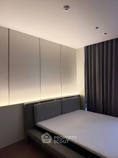 Modern bedroom with sleek design and ambient lighting, featuring a comfortable bed and stylish curtains.