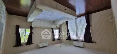 Spacious bedroom with large windows and air conditioning units, featuring a unique ceiling design.
