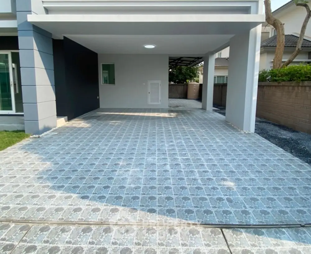Spacious modern driveway with elegant tiled flooring and covered parking area.