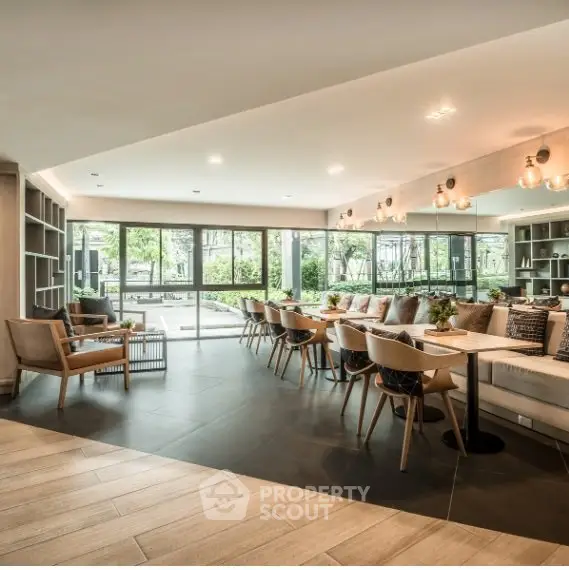 Spacious modern living room with elegant seating and large windows overlooking greenery.