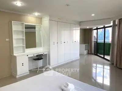 Spacious bedroom with built-in wardrobe and balcony access in modern apartment