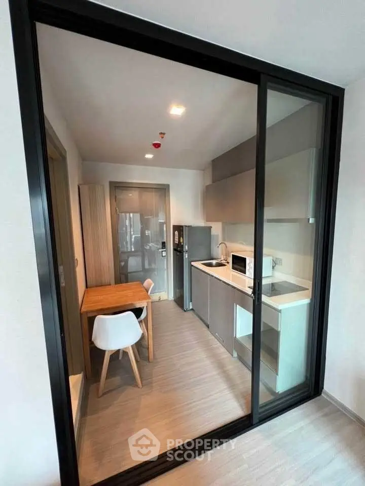 Modern compact kitchen with sleek design and dining area in a stylish apartment.