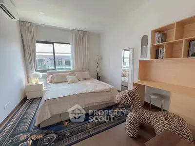 Spacious bedroom with elegant decor and ample natural light, featuring a cozy bed and stylish furnishings.