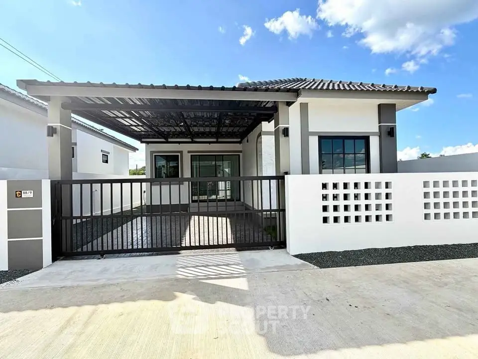 Modern single-story house with gated driveway and sleek design