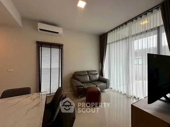 Modern living room with sleek furniture and large windows for natural light.