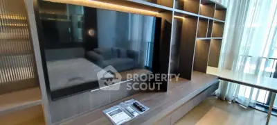 Modern living room with sleek TV unit and cozy seating area, perfect for relaxation.