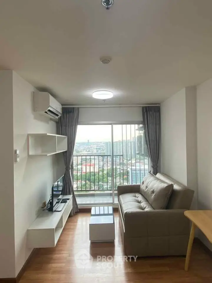 Modern living room with city view, featuring sleek furniture and large windows for natural light.