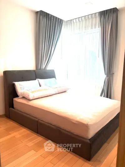 Spacious bedroom with elegant curtains and modern bed in bright apartment