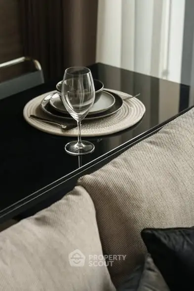 Elegant dining setup with wine glass on modern table in stylish living room.