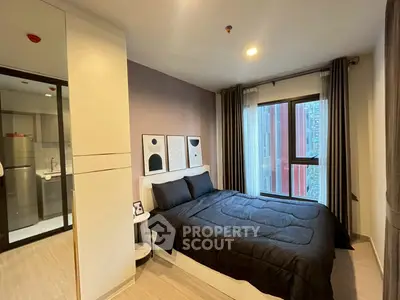Modern bedroom with stylish decor and city view window in a high-rise apartment.