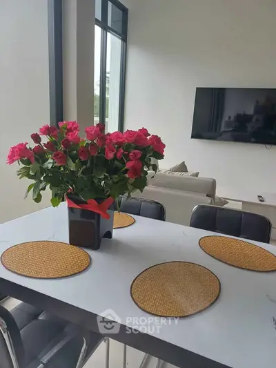 Modern living room with elegant dining area and vibrant floral centerpiece