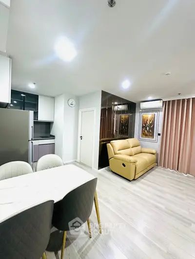 Modern open-layout living room with stylish kitchen and cozy seating area.