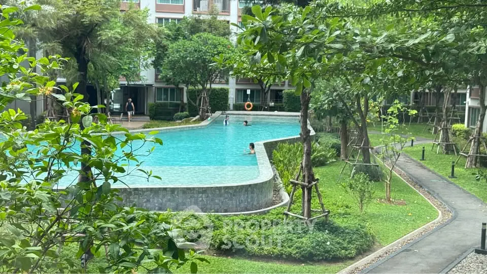 Luxurious residential pool surrounded by lush greenery and modern architecture, perfect for relaxation and leisure.