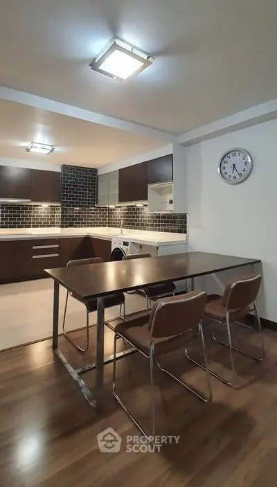 Modern kitchen with dining area featuring sleek cabinetry and stylish lighting.