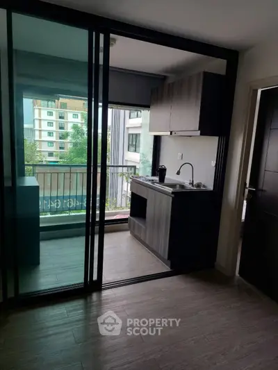 Modern apartment with sleek kitchen and balcony view, perfect for urban living.