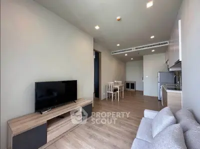 Modern living room with sleek furniture and open kitchen layout in a stylish apartment.