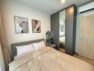 Modern bedroom with stylish decor and mirrored wardrobe in a cozy apartment.