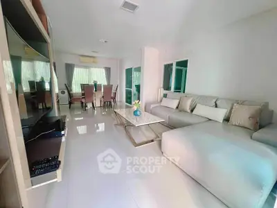 Spacious living room with modern sectional sofa and dining area, perfect for family gatherings.