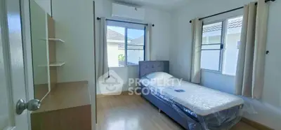 Cozy bedroom with single bed and natural light from two windows