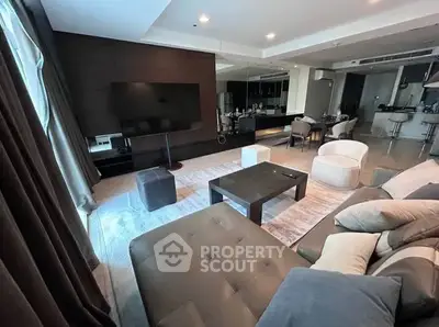 Luxurious modern living room with sleek furniture and open kitchen layout, perfect for entertaining.