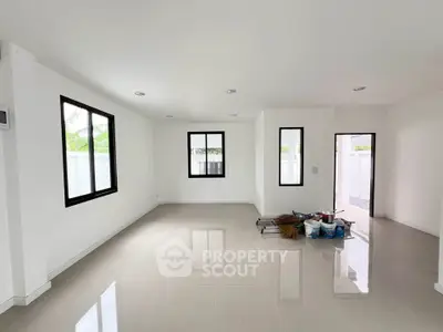 Spacious empty living room with large windows and glossy tiled floor, ready for customization.