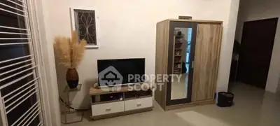 Modern living room with TV stand, wardrobe, and decorative plant