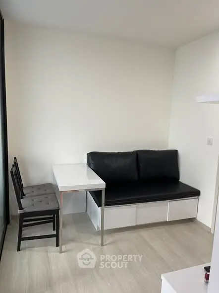 Modern minimalist living area with sleek black sofa and white table