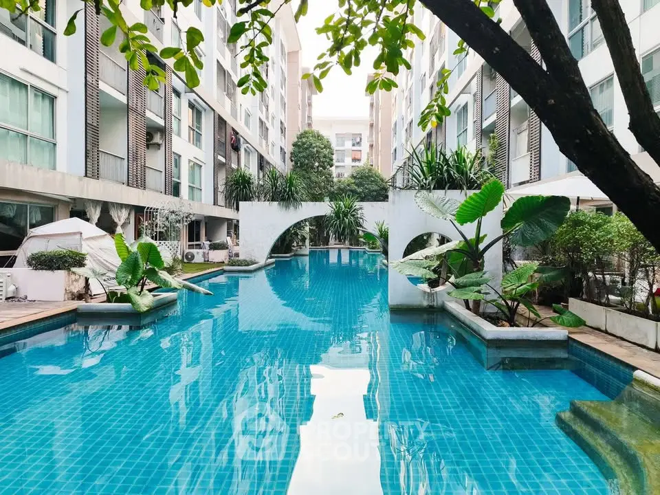 Luxurious residential pool surrounded by modern architecture and lush greenery, perfect for relaxation and leisure.