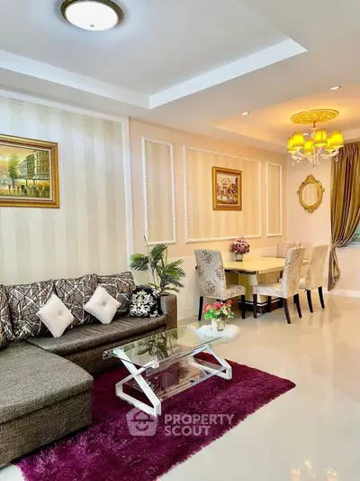 Elegant living room with modern decor and dining area, featuring plush sofa and stylish lighting.