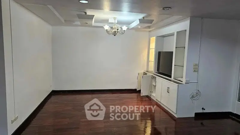 Spacious living room with wooden flooring and built-in TV cabinet.