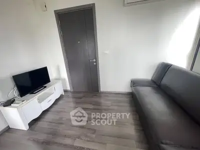 Modern minimalist living room with sleek furniture and wooden flooring.