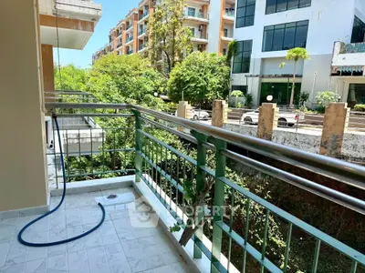 Spacious balcony with lush green view in modern apartment complex