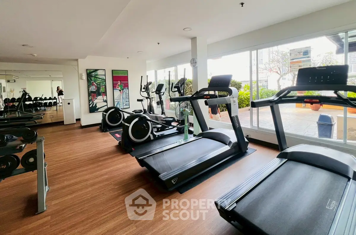 Modern gym with state-of-the-art equipment and large windows for natural light.