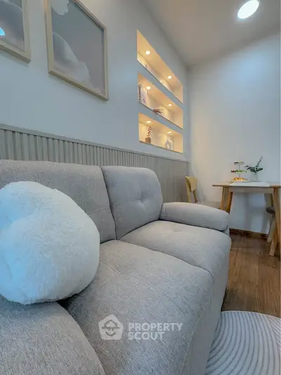 Cozy living room with plush sofa and elegant wall decor, perfect for relaxation and entertaining.