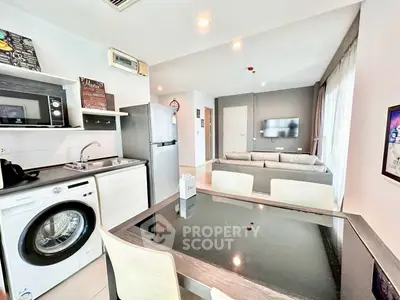 Modern open-plan living area with kitchen, dining, and lounge space featuring sleek appliances.