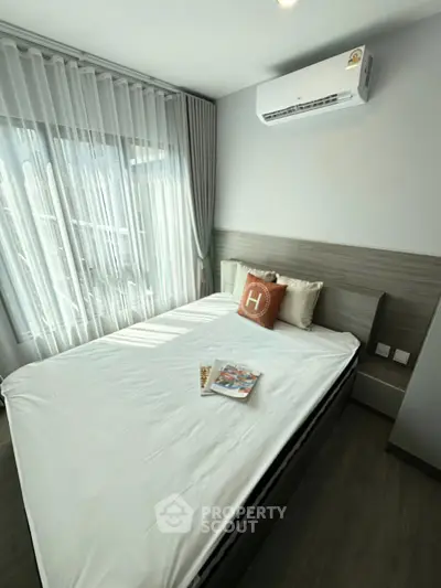 Modern bedroom with air conditioning and stylish decor, featuring a cozy bed and natural light.