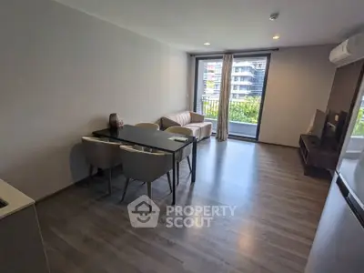 Modern living room with sleek furniture and balcony view in a stylish apartment.