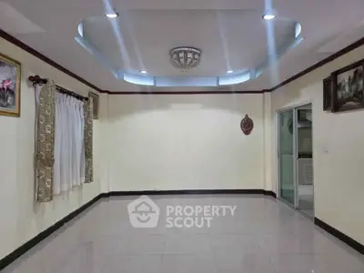 Spacious empty room with elegant ceiling design and tiled flooring