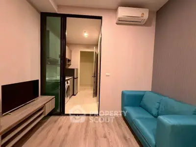 Modern living room with blue sofa and sleek TV setup in a stylish apartment.