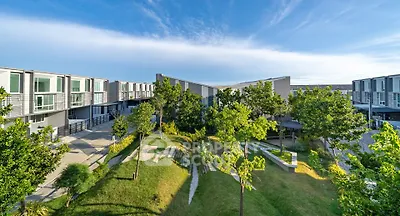 Modern townhouse complex with lush green landscaping and clear blue sky.