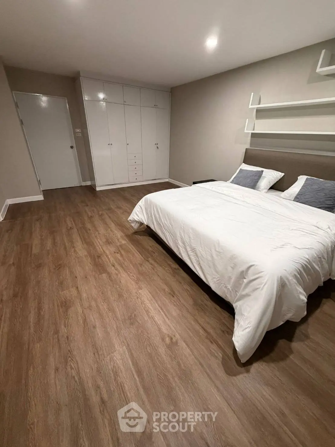 Spacious bedroom with wooden flooring and modern decor