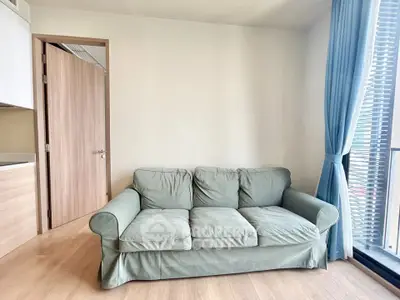 Cozy living room with a comfortable sofa and large window for natural light.
