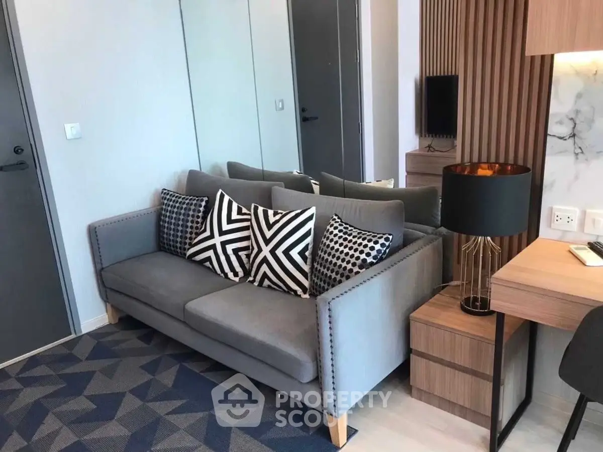 Modern living room with stylish grey sofa and geometric cushions