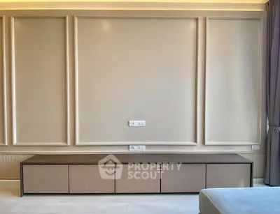 Elegant modern living room with stylish wall paneling and sleek storage unit.