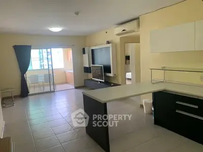 Spacious open-plan living room with modern kitchen and ample natural light.