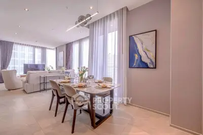 Luxurious open-plan living and dining area with elegant decor and large windows.