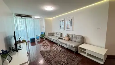 Spacious modern living room with sleek furniture and natural light, perfect for relaxation and entertainment.
