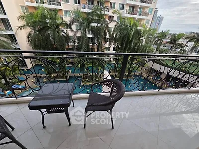 Luxurious balcony view overlooking a tropical pool and lush palm trees, perfect for relaxation and leisure.