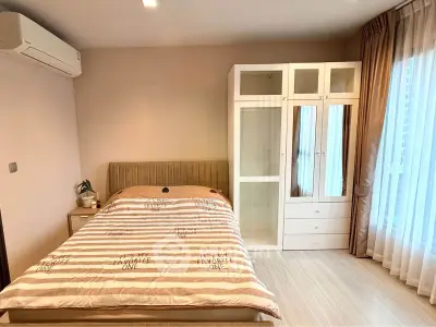 Spacious bedroom with modern decor and large window for natural light
